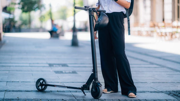 Ein Mann steht neben dem E-Scooter