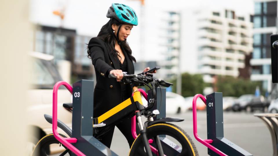 Eine Frau findet eine Ladestation für ein E-Bike - E-Bike Aufladen Unterwegs leicht gemacht